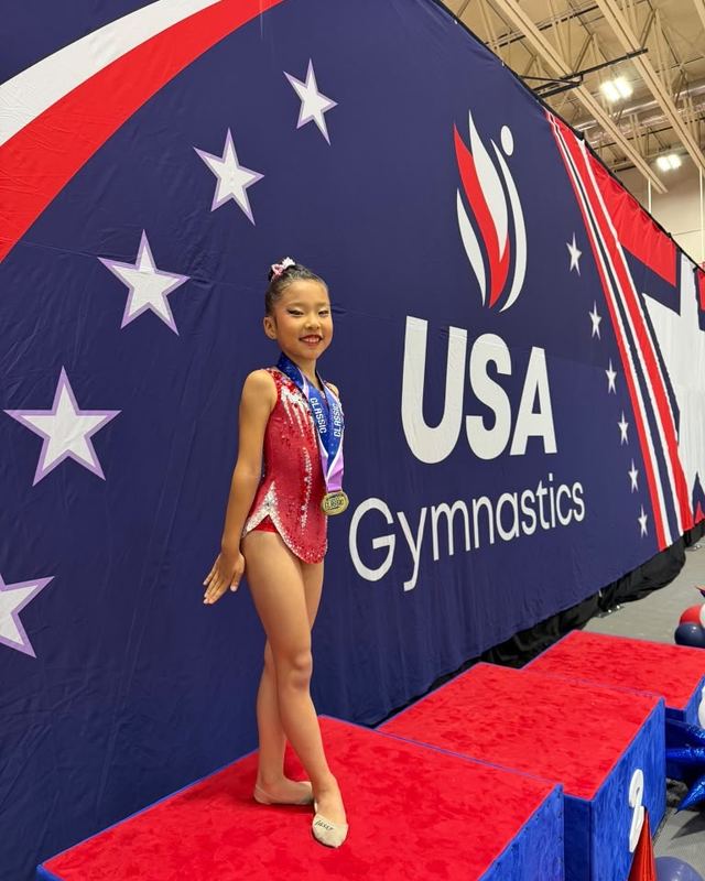 A gymnast walking out onto the carpet at a USA Gymnastics meet